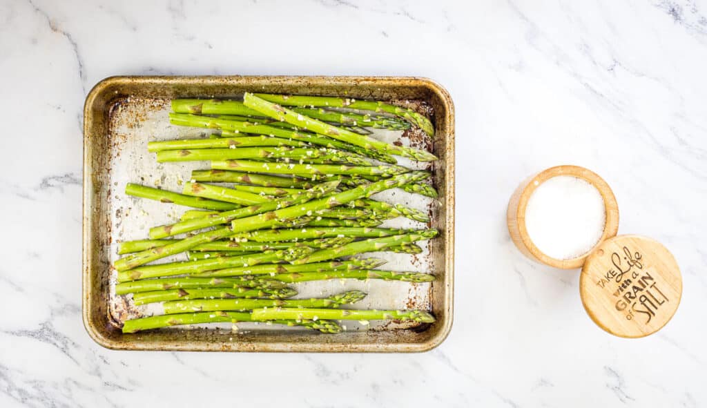Washed asparagus on a baking sheet.