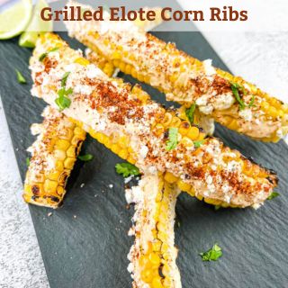 Grilled elote corn ribs on a black platter.