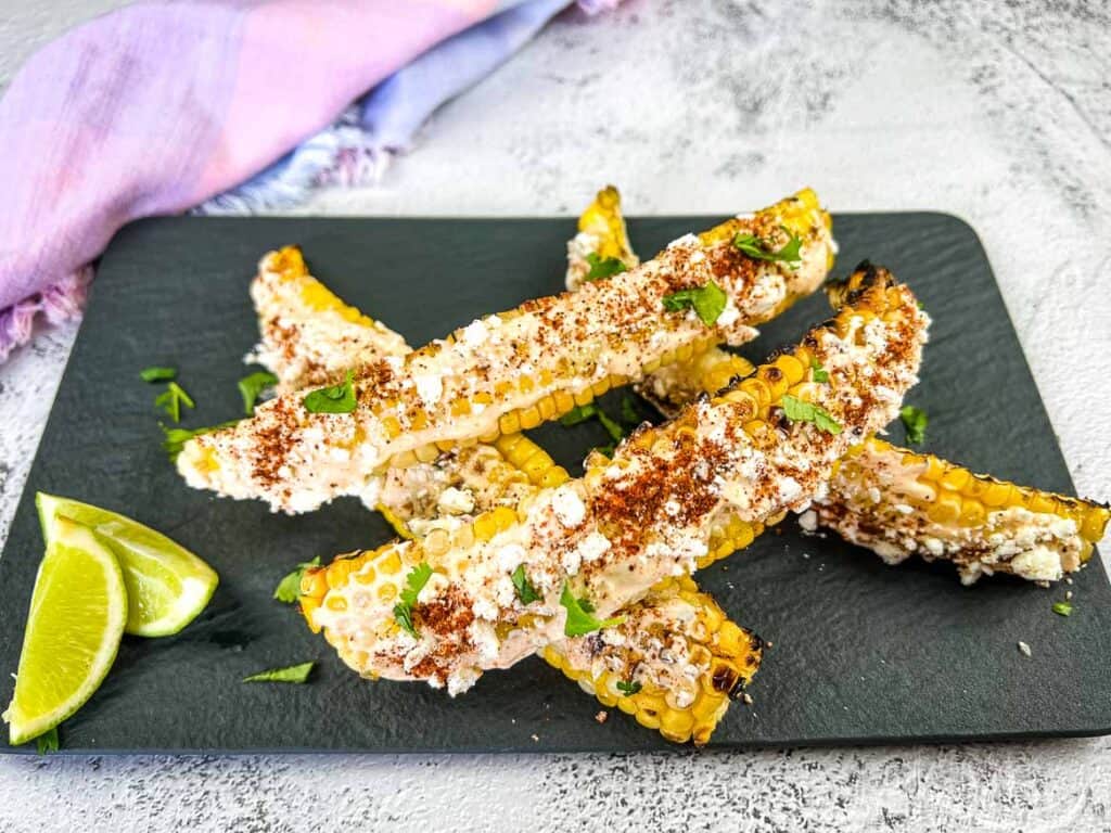 Grilled Elote Corn Ribs on a black platter.