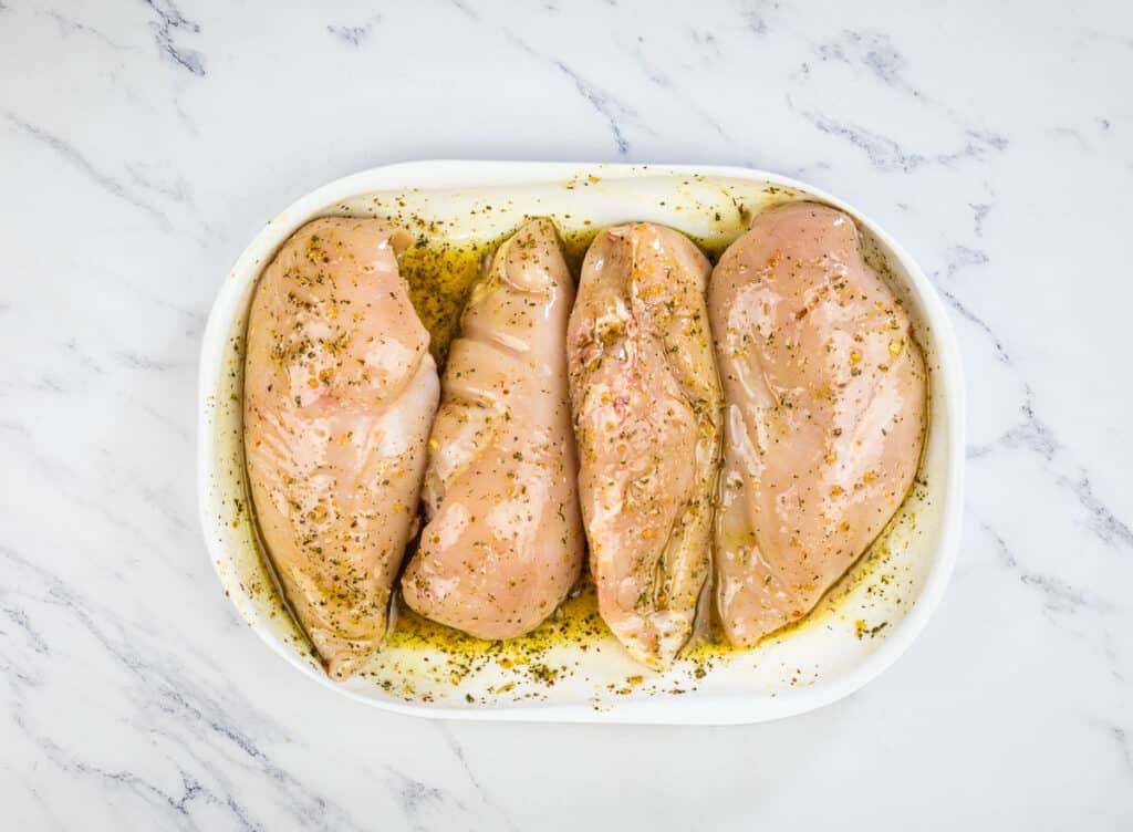 Marinating chicken breasts on a plate.