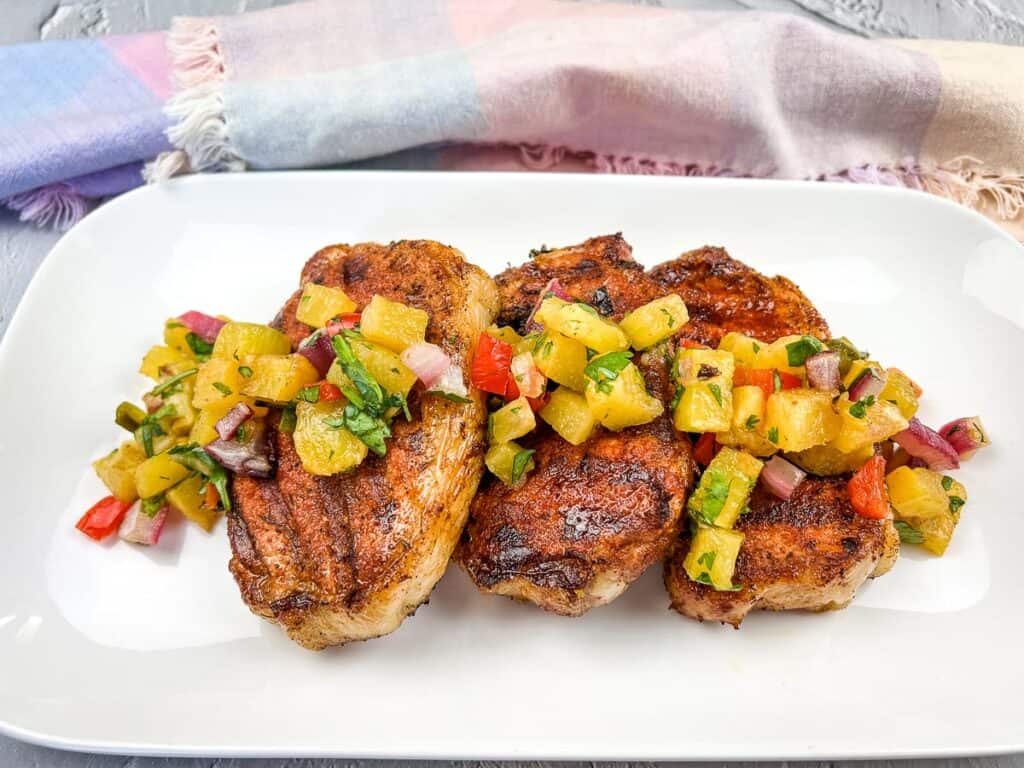 Ninja Woodfire Grill Smoked Pork Chops with Grilled Pineapple Salsa on a white plate.