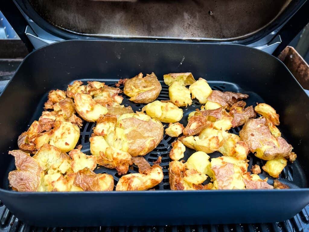 Cooked Smashed Potatoes in an air fryer basket.