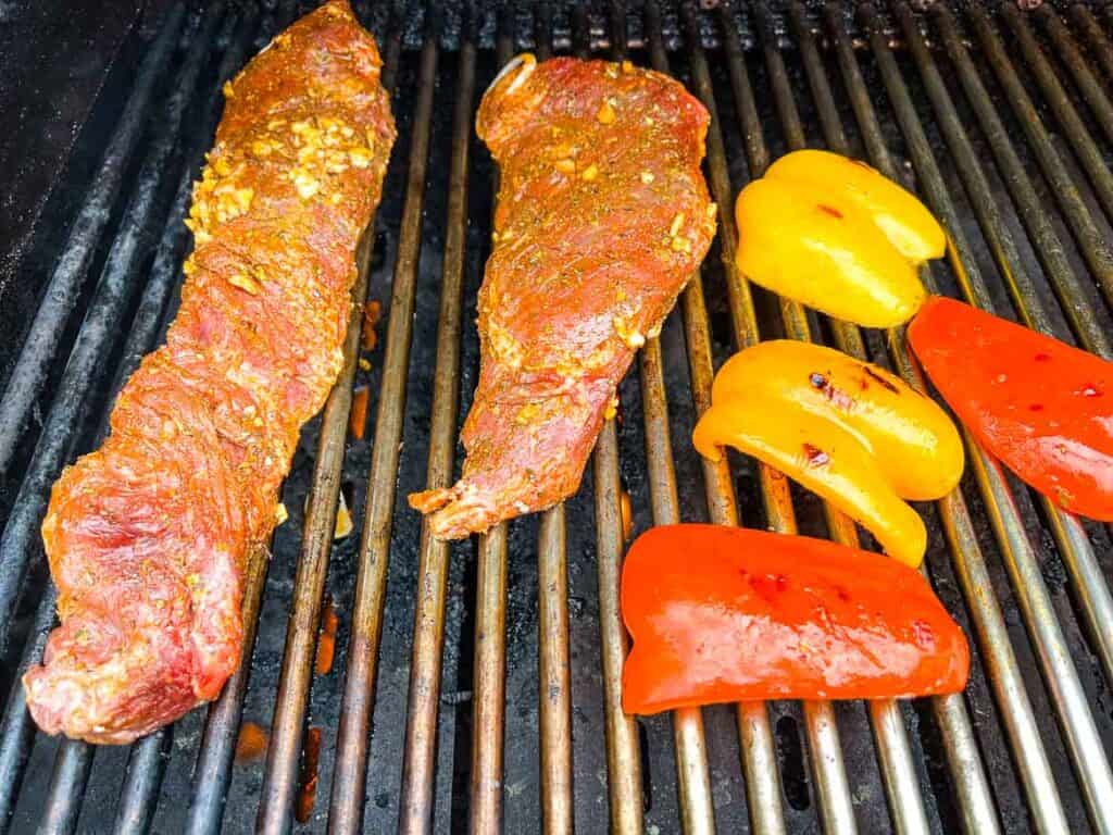 Hanger steaks and peppers on the grill.