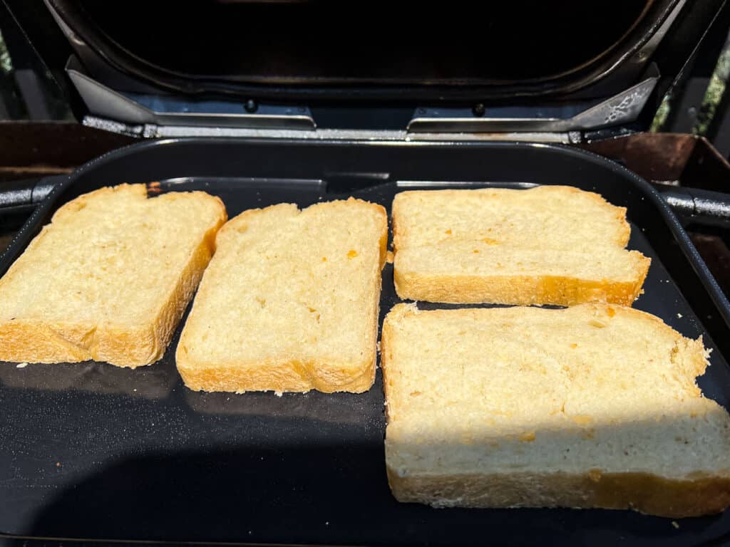 Butter one side of each slice of sourdough bread evenly.