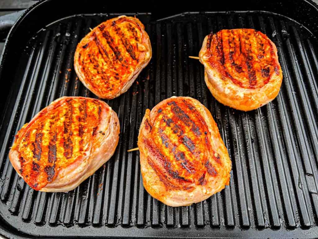 Watch the bacon to avoid burning. If it crisps too quickly, move the chicken to a cooler part of the grill.