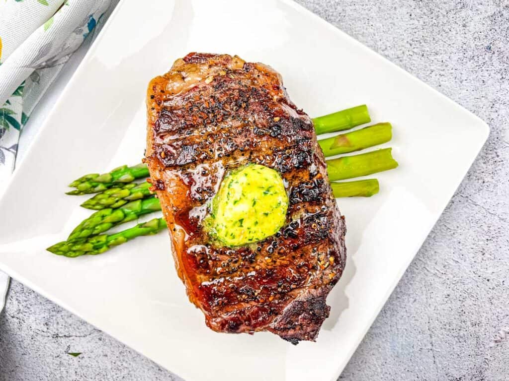 Smoked Reverse-Seared Steaks with Smoked Garlic Butter on a white plate.