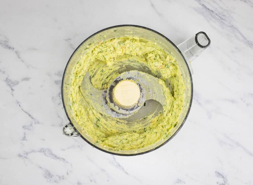 Ingredients to make smoked garlic butter in a food processor.