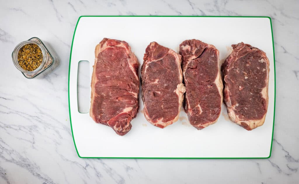 Season the steaks generously on both sides.