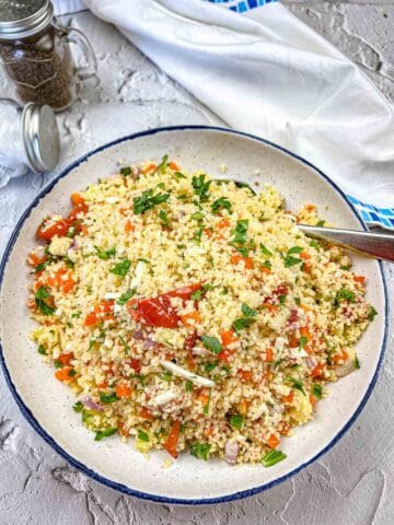 A serving bowl of Mediterranean Couscous with Tomatoes.