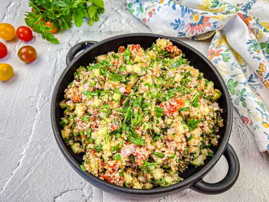 Tabouli Salad with Smoked Tomatoes on a black skillet.