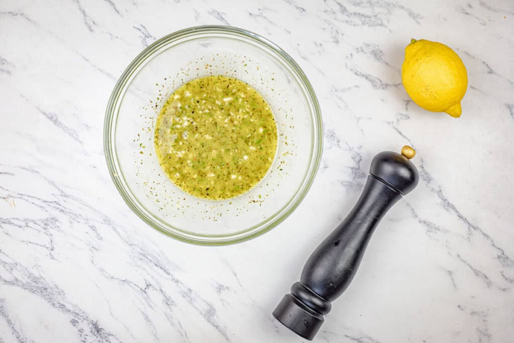Mix olive oil, lemon juice, garlic, rosemary, thyme, oregano, Dijon mustard, honey, onion powder, salt, and pepper in a small bowl.