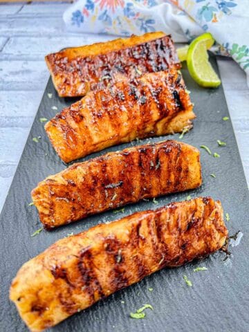 Grilled Pineapple With Buttery Lime Glaze served on a black slate plate.