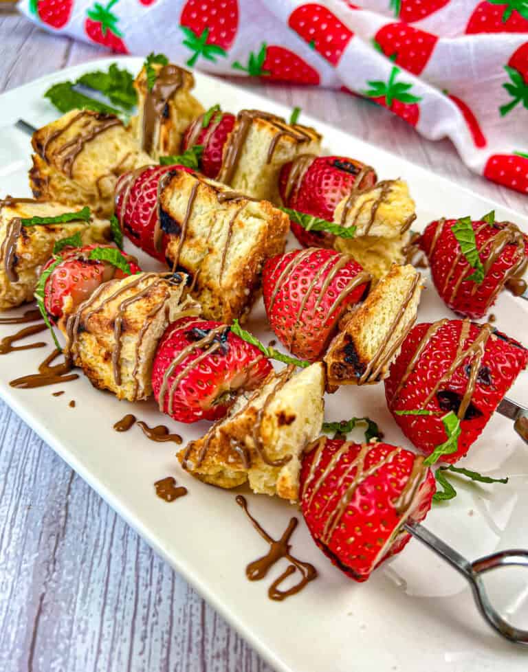 Three pieces of Grilled Strawberry Shortcake Skewers on a plate.