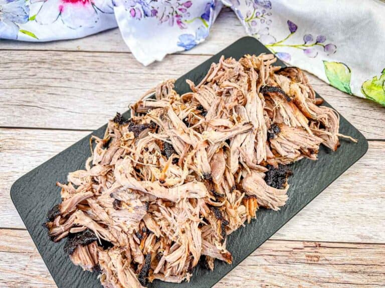Ninja Woodfire Outdoor Grill Smoked Pulled Pork on a black slate plate.