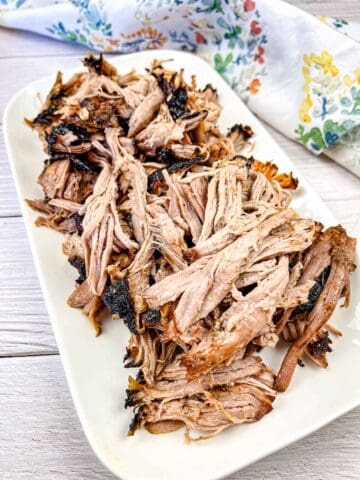 Ninja Woodfire Outdoor Grill Smoked Pulled Pork on a white plate.