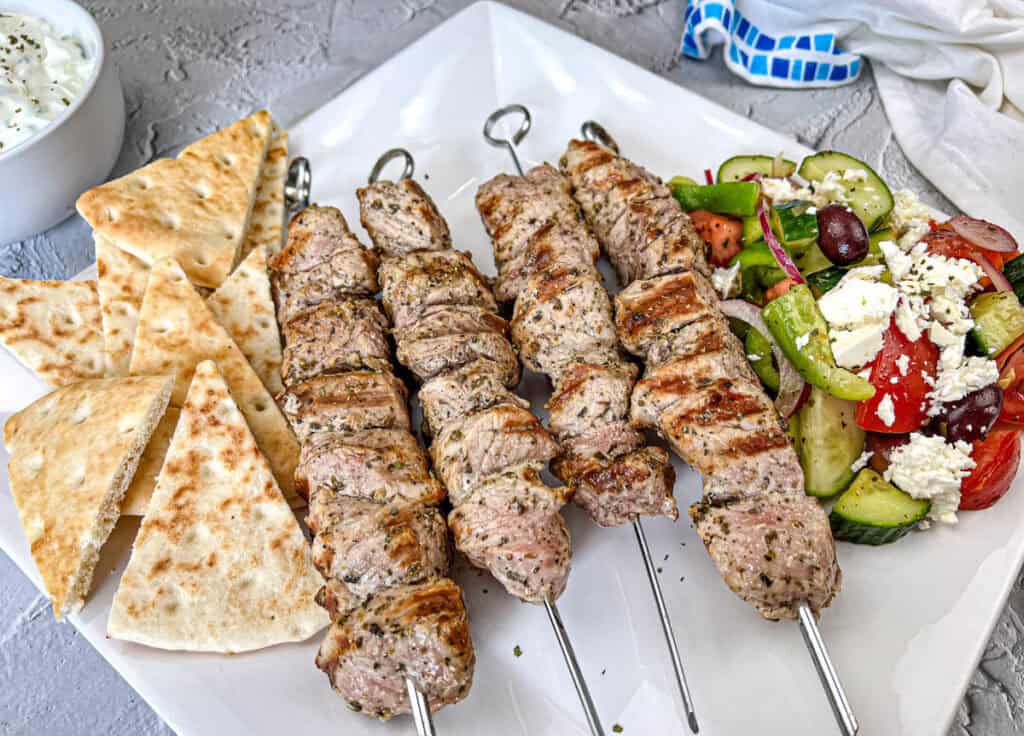 Ninja Woodfire Pork Souvlaki with Horiatiki Salad on a white plate.
