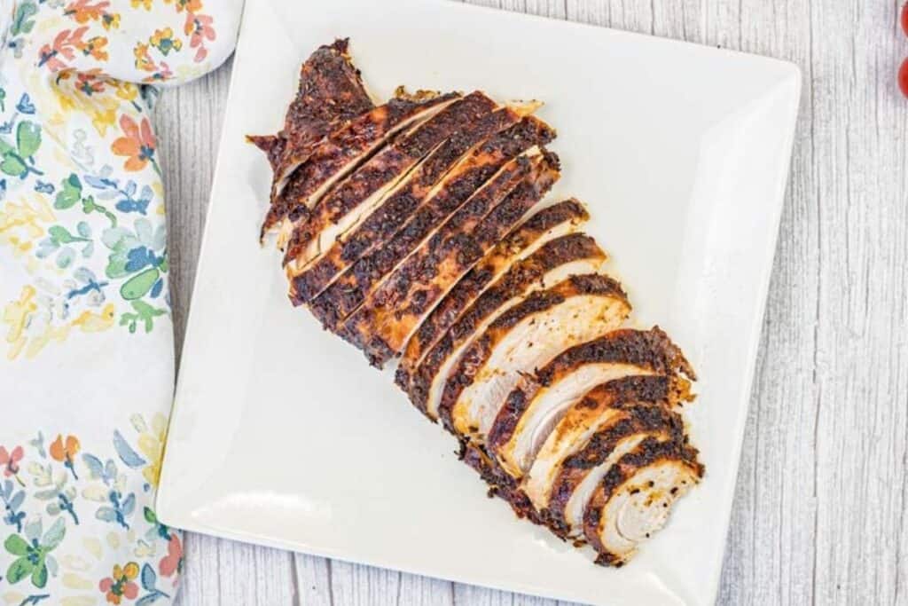 Top-down shot of Smoked turkey breast on a white plate.