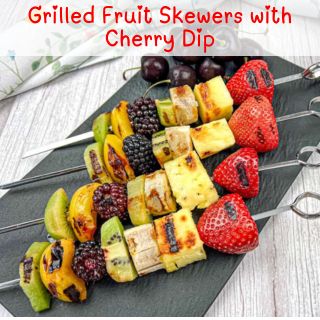 Grilled Fruit Skewers with Cherry Dip on black slate.