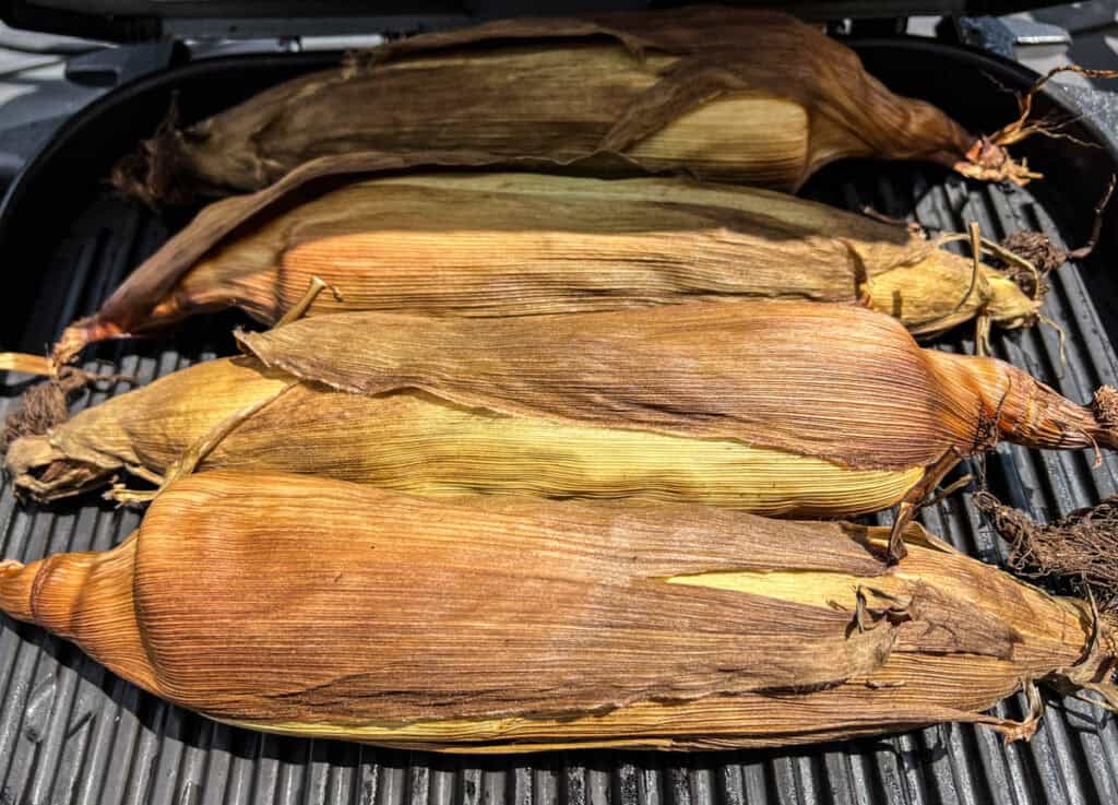 Place the whole cobs of corn - husks and all - into the Ninja and close the lid.