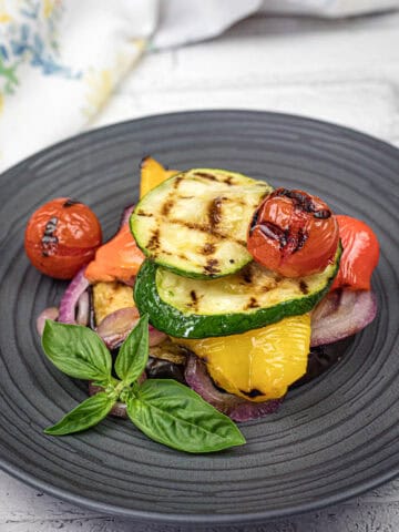 Grilled Ratatouille on a black plate.