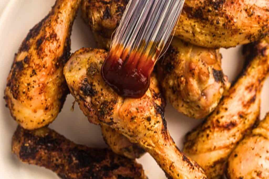 Brush the drumsticks lightly with BBQ sauce using a silicone basting brush.