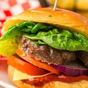 A grilled beef burger on a plate.