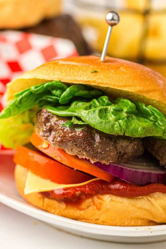 A grilled beef burger on a plate.