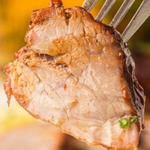 A fork holding a piece of Grilled Pork Tenderloin.