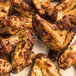 Grilled chicken wings on a white plate.