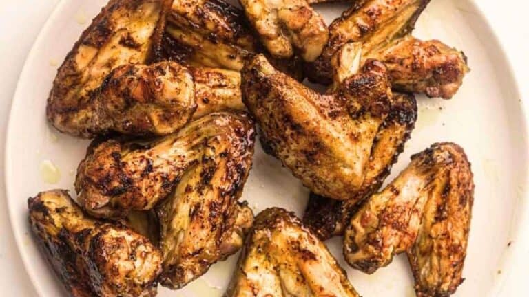 Grilled chicken wings on a white plate.