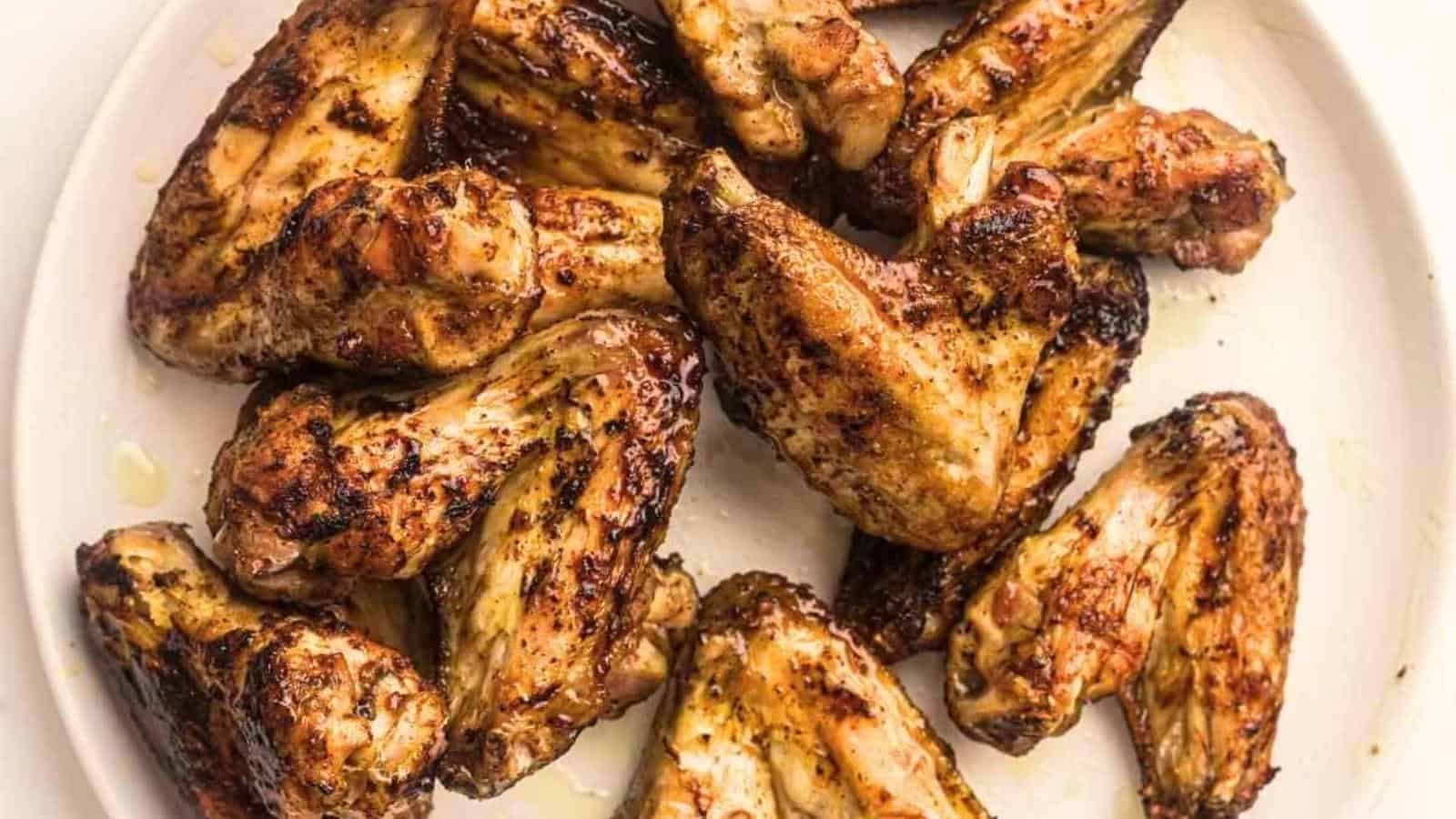 Grilled chicken wings on a white plate.